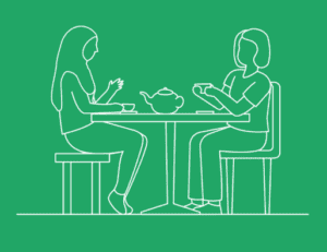 two people sitting at a table drinking tea