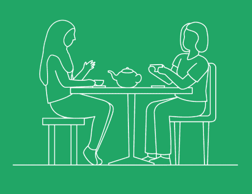two people sitting at a table drinking tea