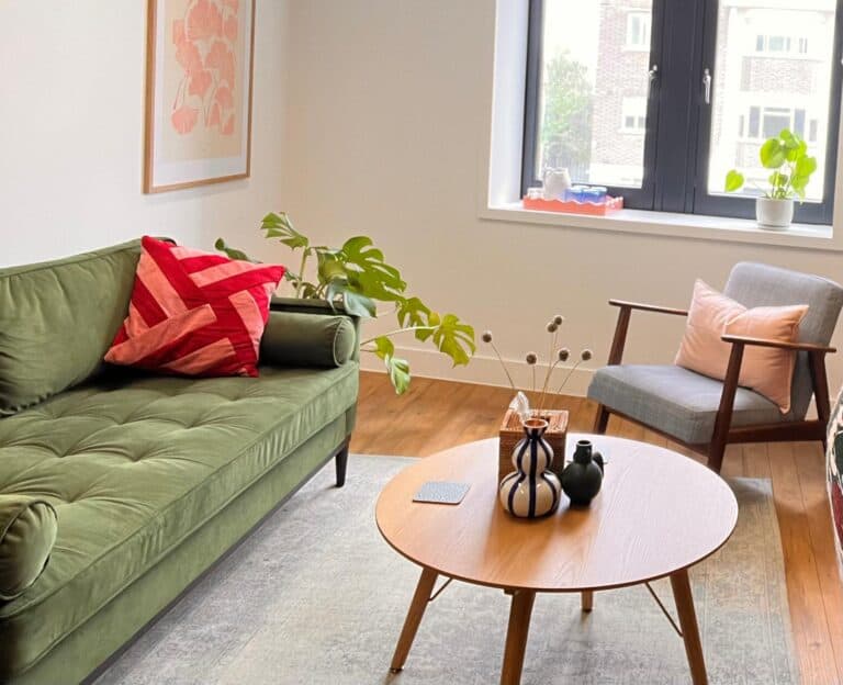Psychology therapy room with green sofa and grey chair and round coffee table