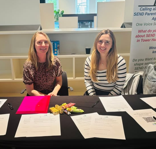 two women on a table with questionnaires