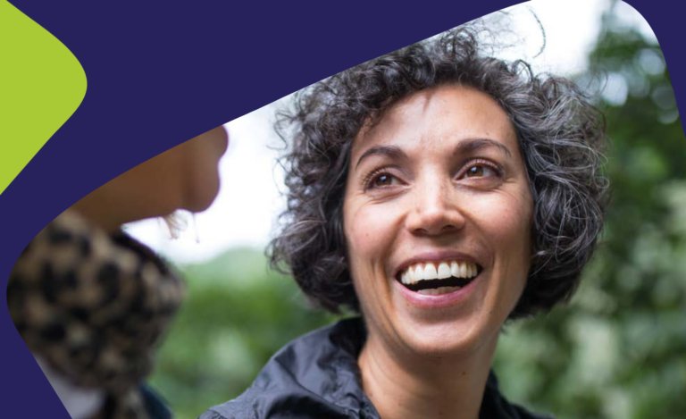 Norfolk ready to change flyer woman smiling with backdrop of purple and green